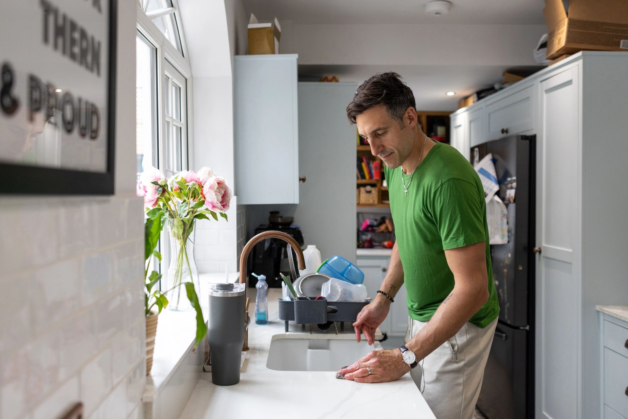 Cleaner wiping a kitchen countertop in a bright modern home